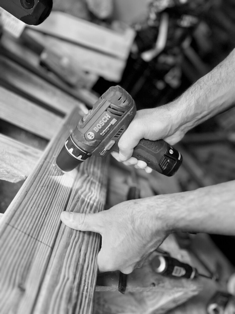 Perçage d'une planche en bois avec une visseuse Bosch dans l'atelier MOByDIY